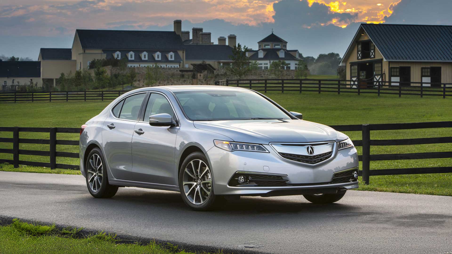 silver acura tlx parked in front of luxury estate with horse stables at sunset