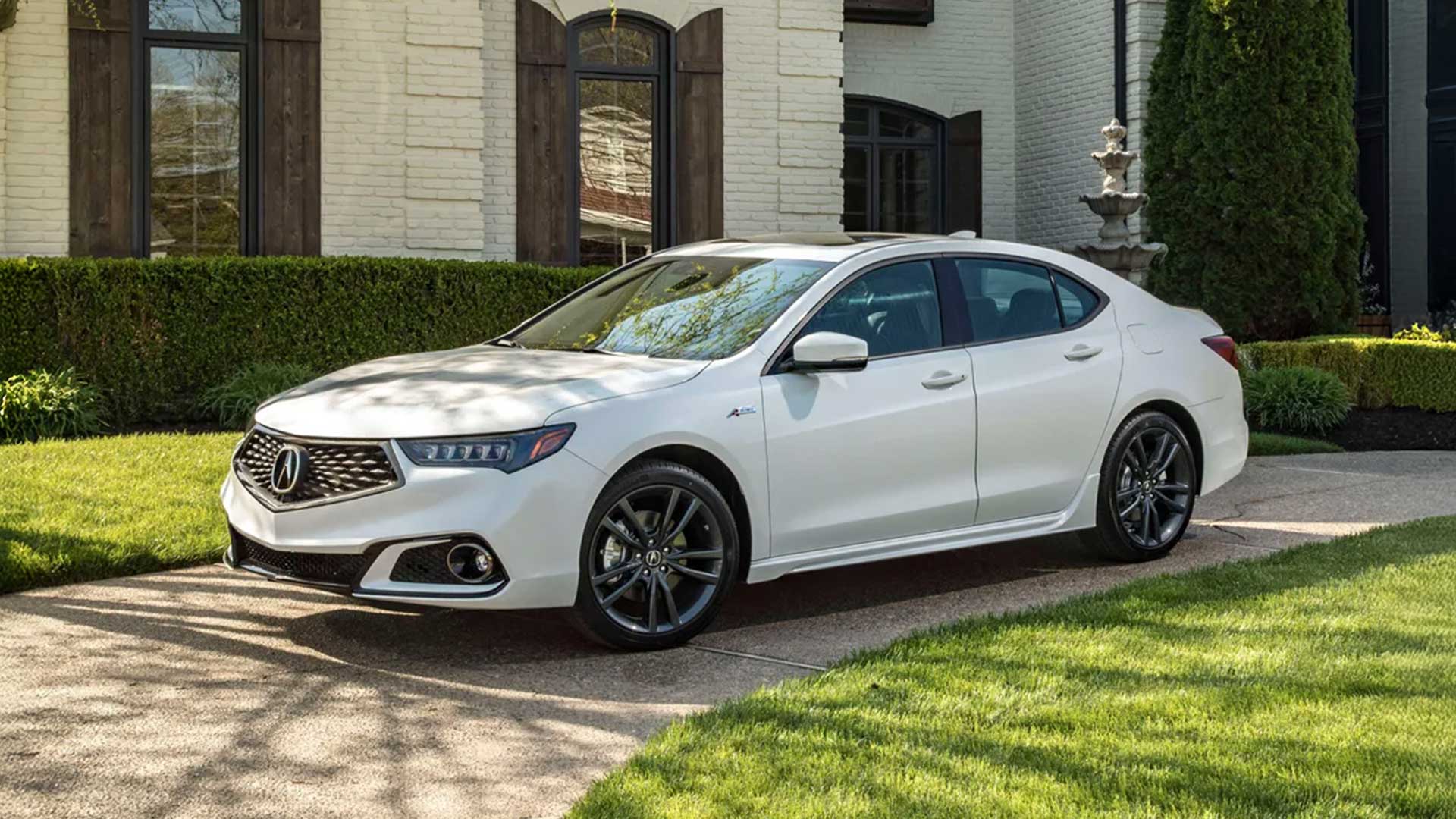 white acura tlx a-spec with dark wheels parked on driveway of upscale home with manicured landscaping