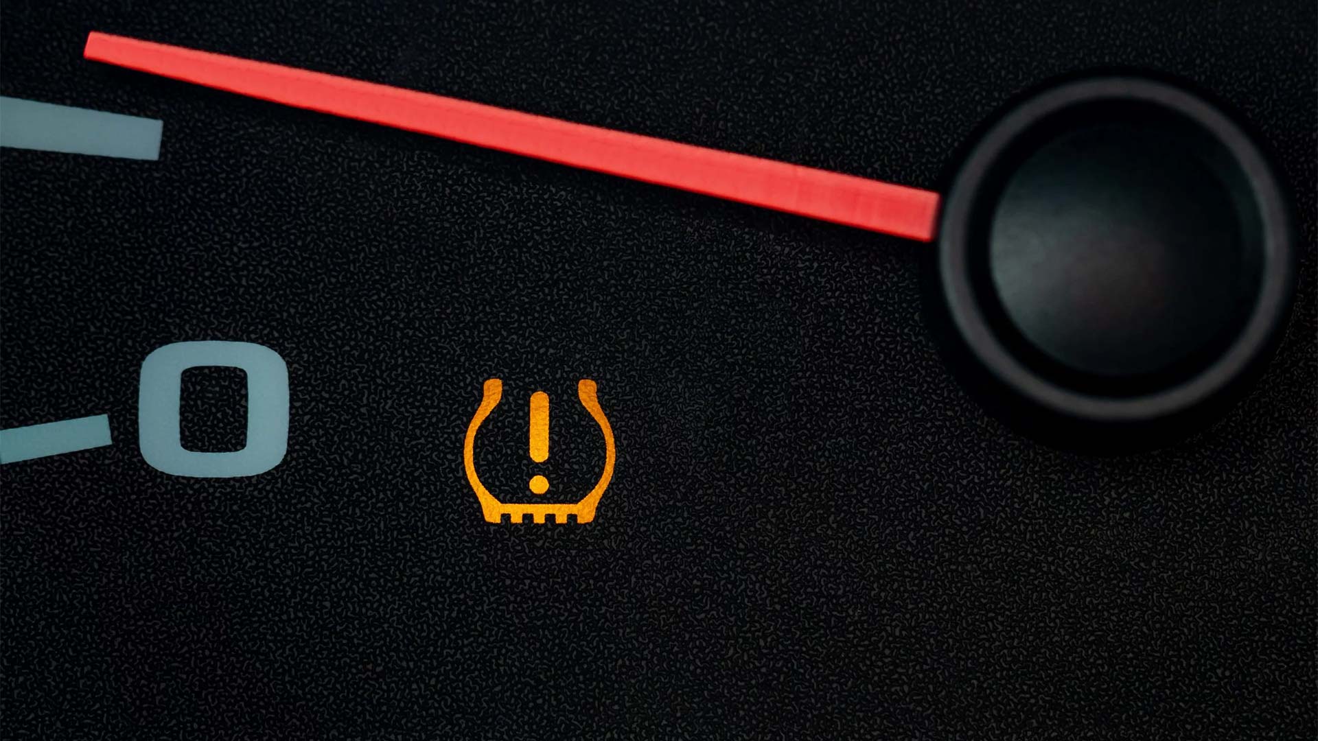 Image of a car dashboard with the low tire pressure warning light on
