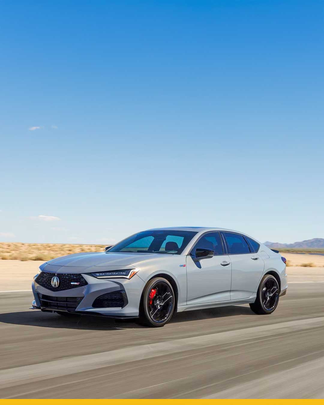 gray acura tlx type s with black wheels and red brake calipers driving on desert road