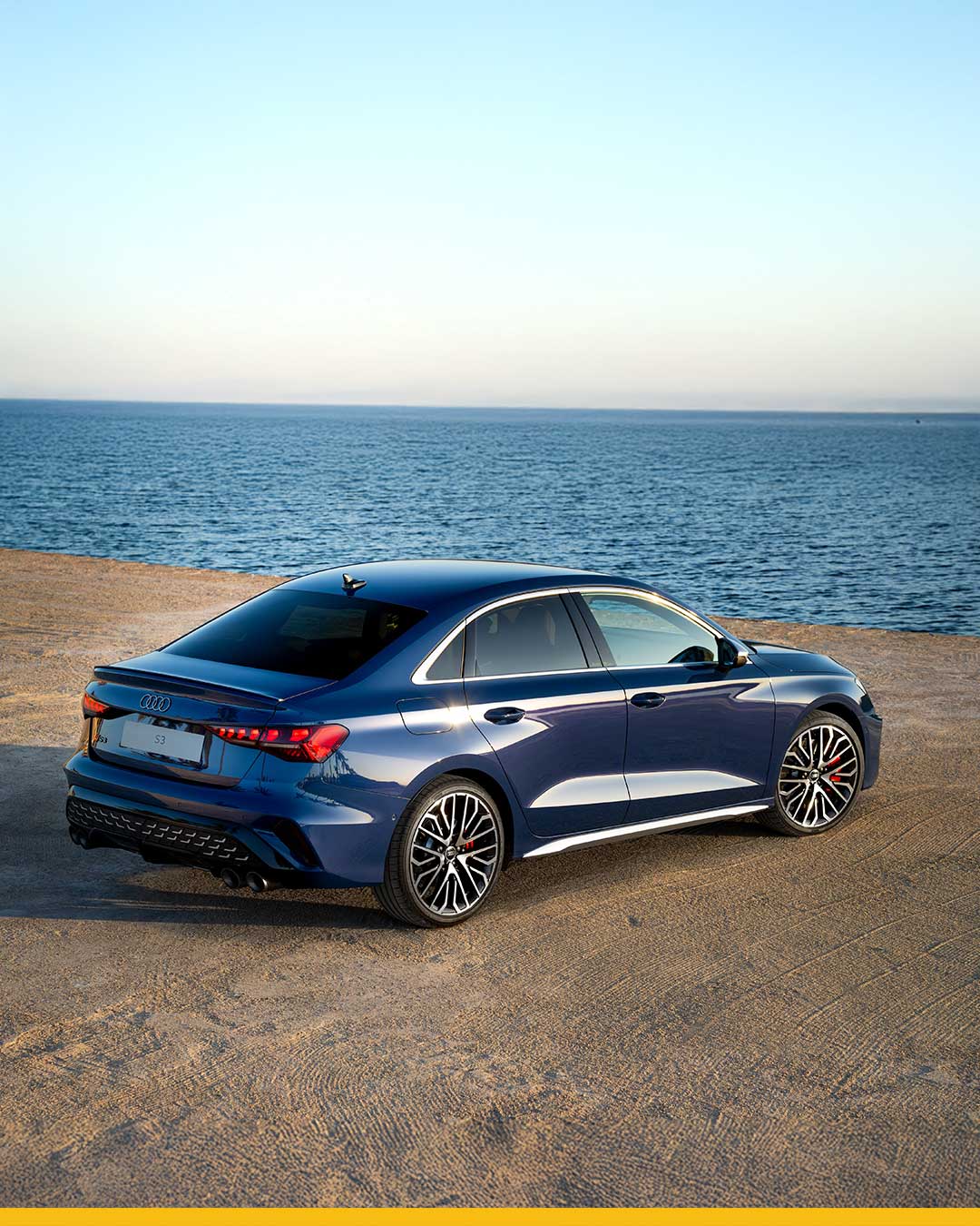dark blue audi s3 8y parked on sand by ocean front